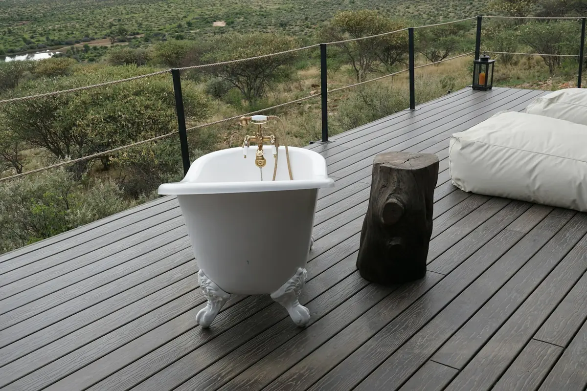 Freistehende Badewanne auf einem Holzdeck mit Blick über die Savanne bei Windhoek